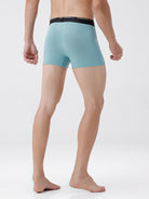 Person wearing light blue boxer briefs with black waistband on a white background