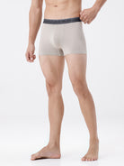 Man wearing beige boxer briefs on a white background