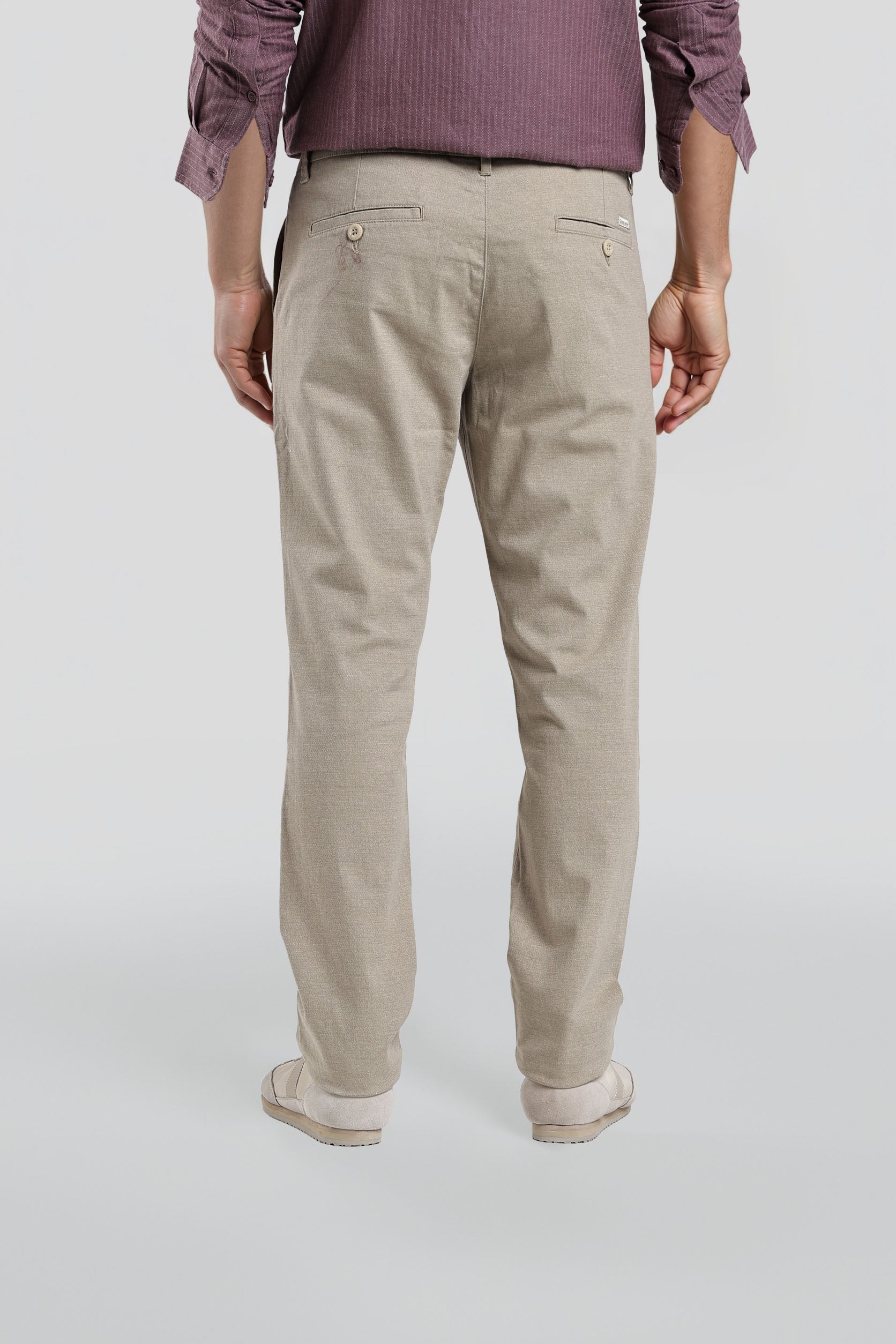 Person wearing beige pants on a white background