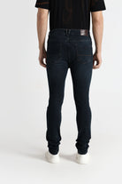 Person wearing dark blue jeans and a black shirt on a white background