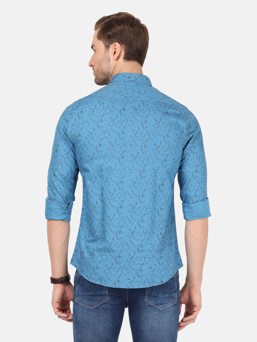 Man wearing a blue river blue printed full sleeve shirt on a light gray background