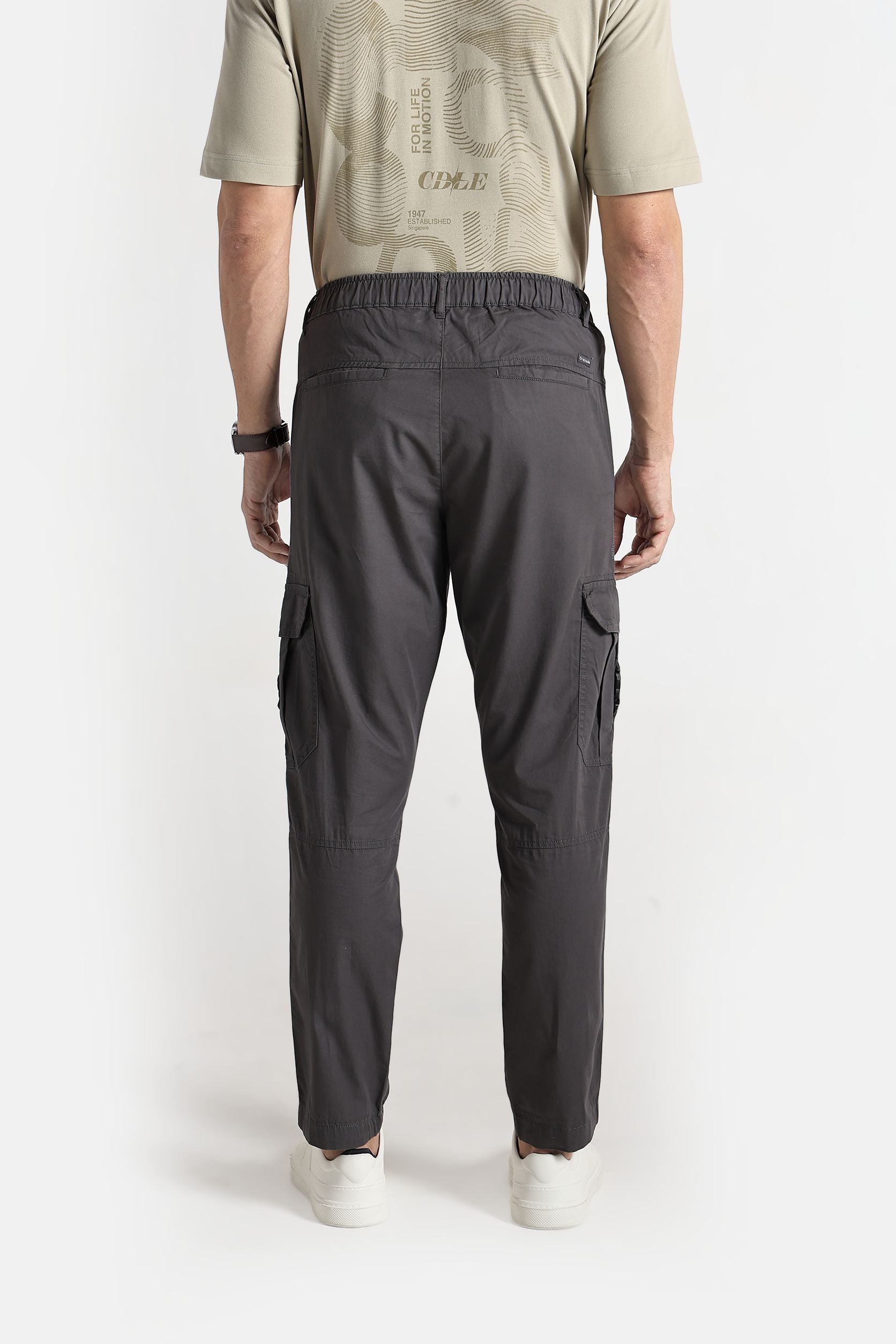 Person wearing gray cargo pants on a white background