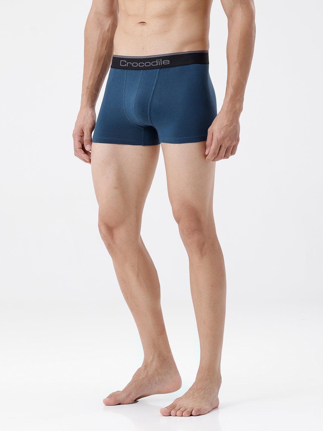 Man wearing blue boxer briefs with a visible brand logo on a white background