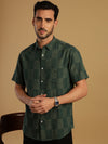 Man wearing a green green checked casual half sleeve 100% cotton shirt on a light gray background