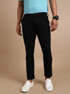 Man wearing a black slim fit black solid casual trouser on a light gray background
