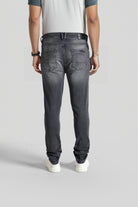 Person wearing black jeans on a plain background