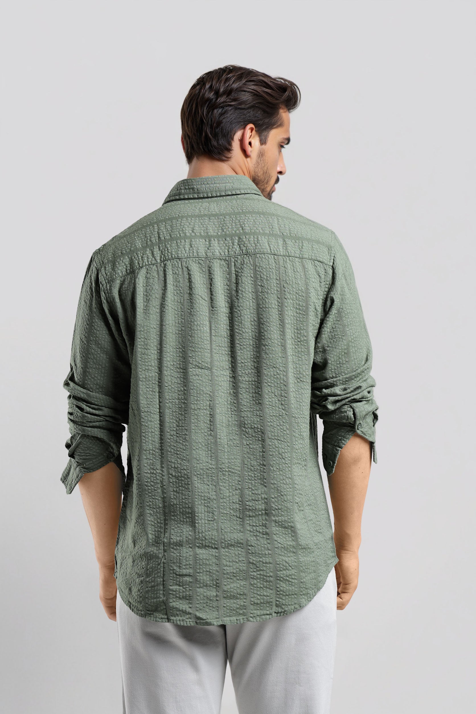 Man wearing a green textured shirt against a white background