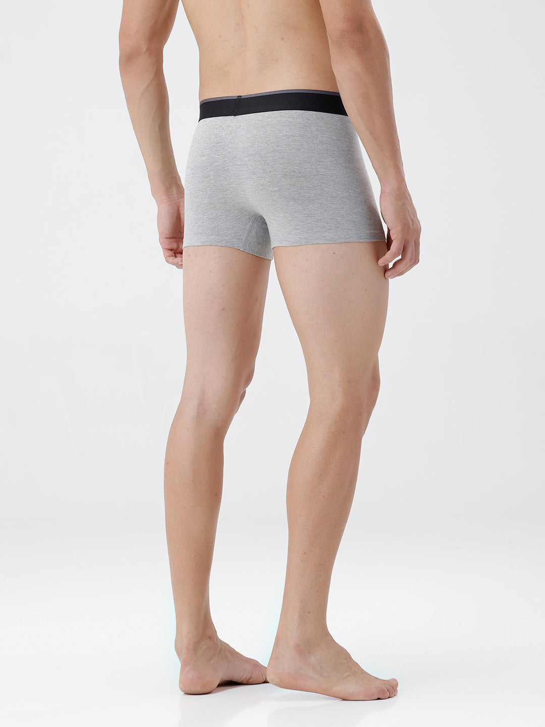 Person wearing gray boxer briefs with black waistband on a white background