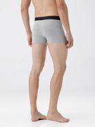 Person wearing gray boxer briefs with black waistband on a white background