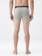 Person wearing light gray boxer briefs with dark waistband on a white background