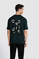 Man wearing a dark green t-shirt with text on the back against a white background