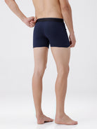 Person wearing navy blue boxer briefs on a white background