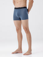 Person wearing a pair of gray boxer briefs on a white background