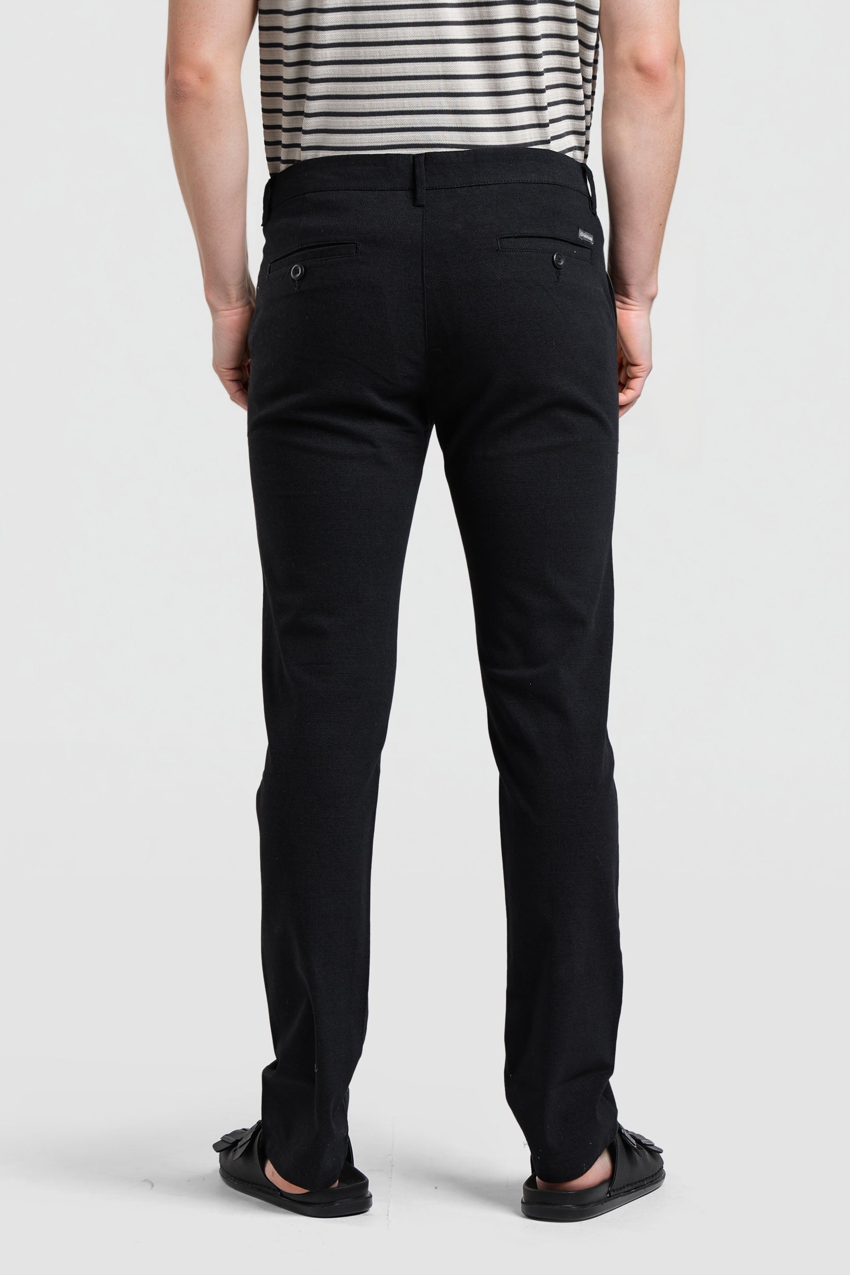 Person wearing black pants on a white background