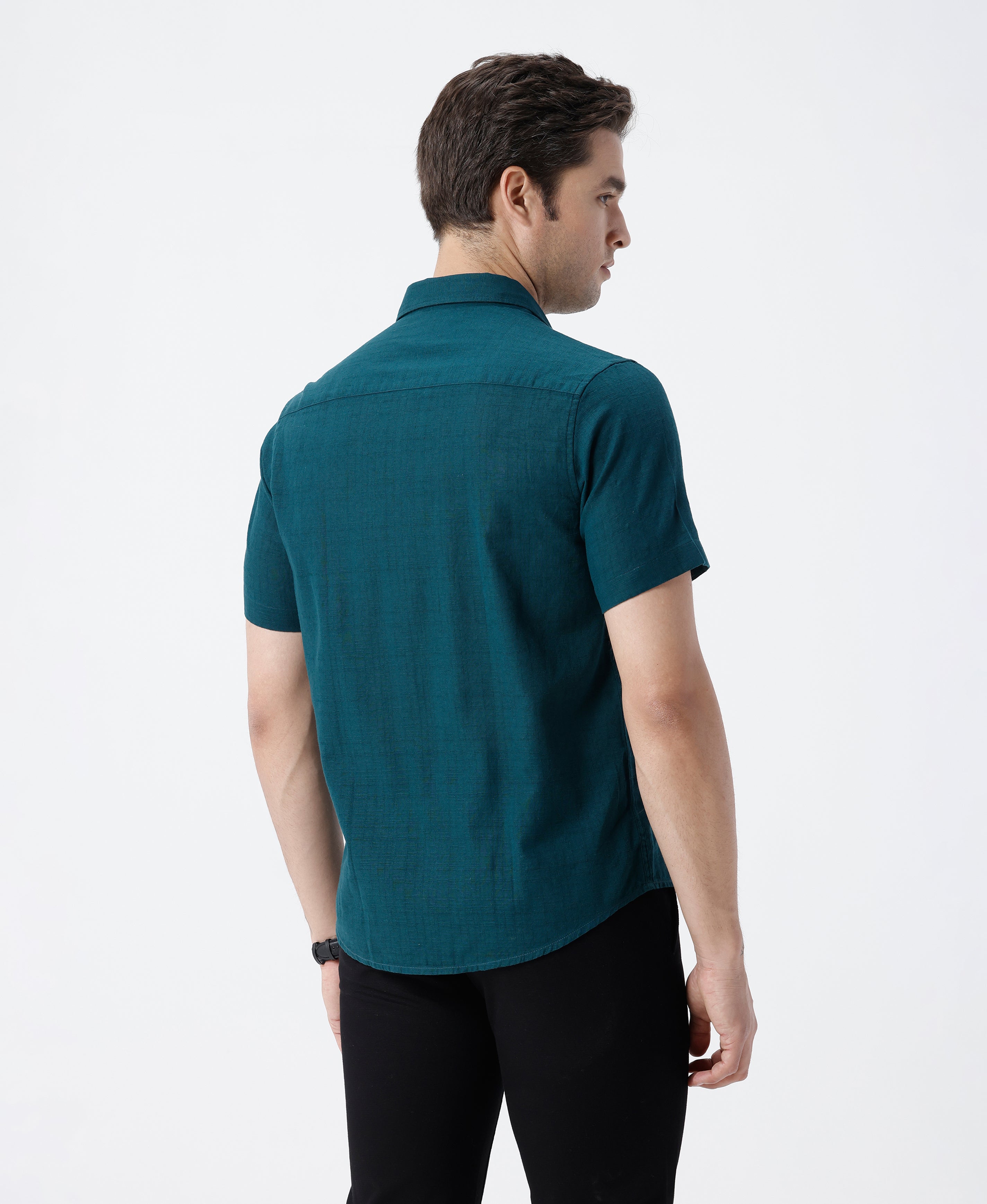 Man wearing a green pure cotton textured shirt green with casual styling on a gray background