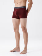 Man wearing maroon boxer briefs on a white background