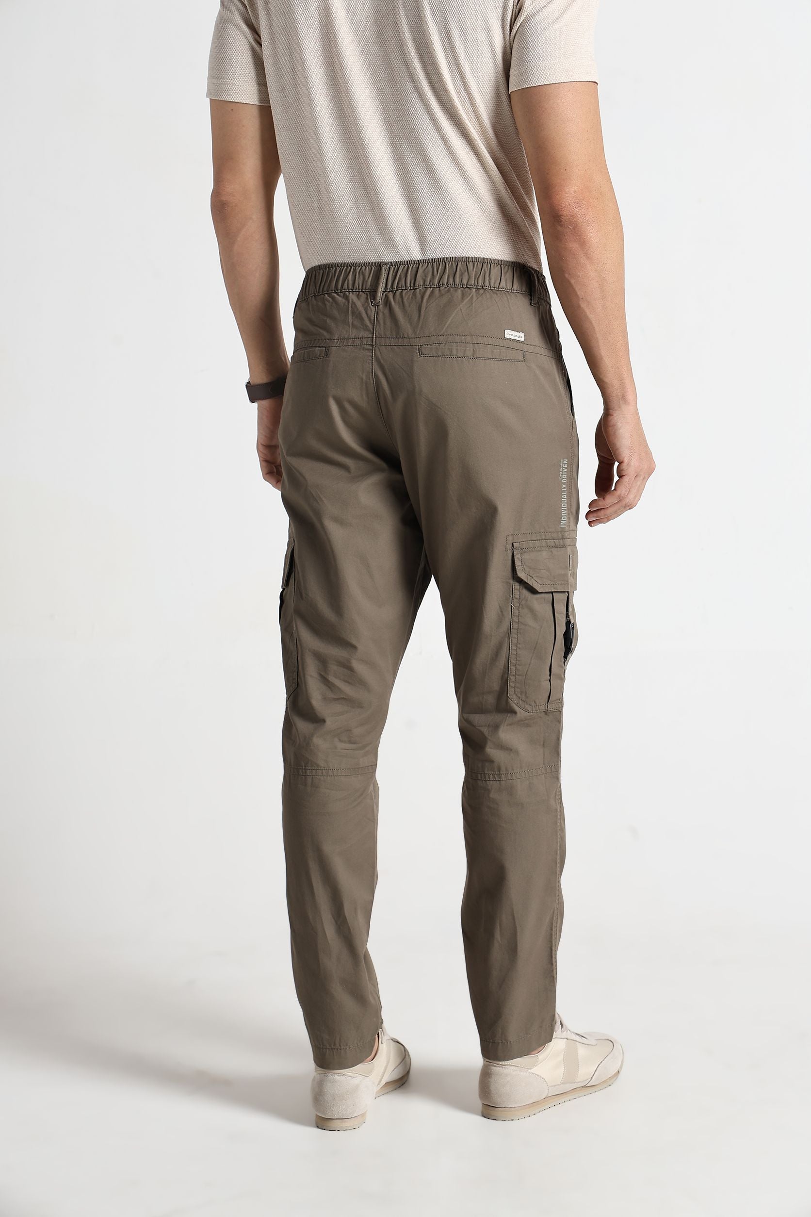 Person wearing brown cargo pants on a white background