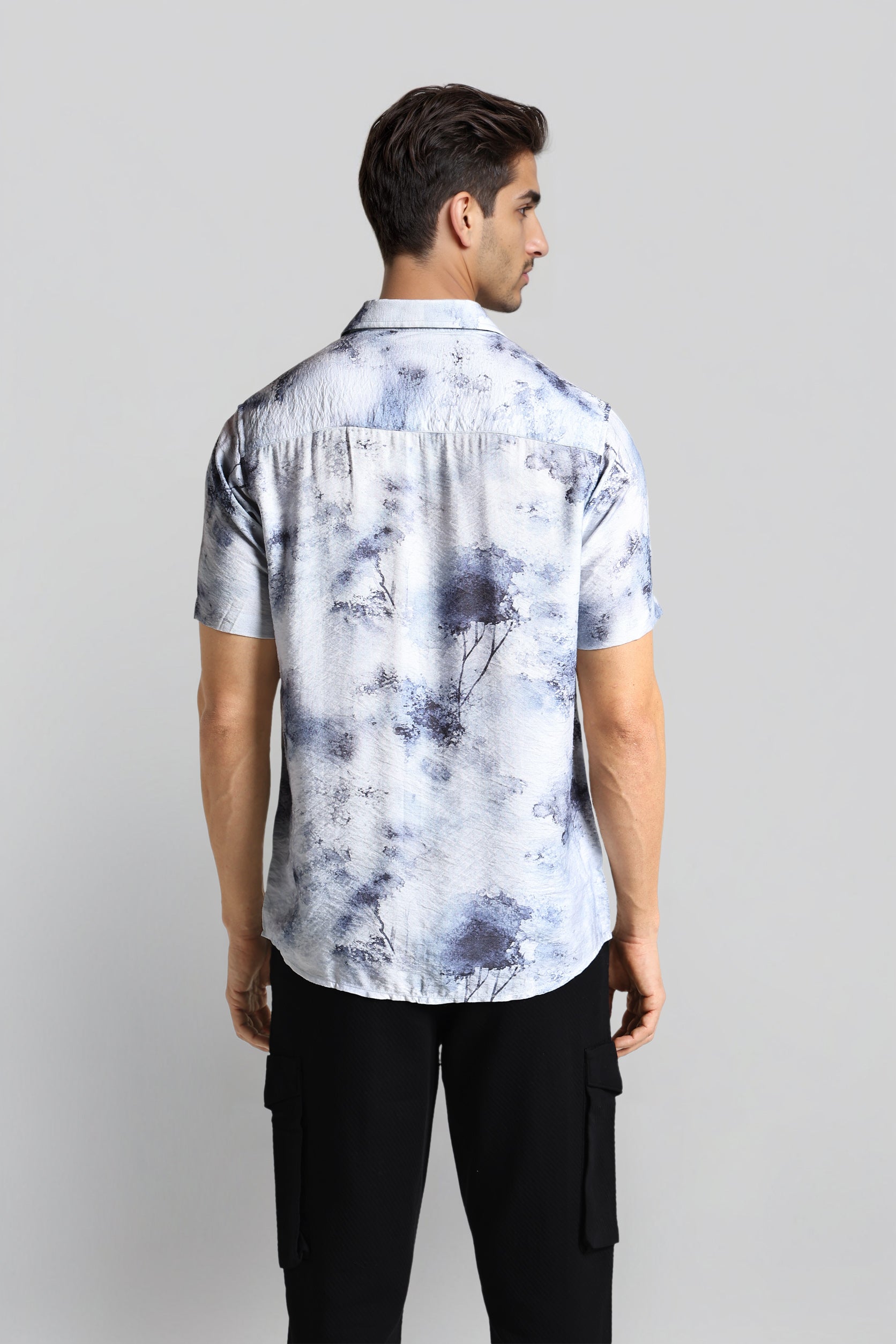 Man wearing a tie-dye shirt with a plain background