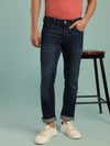Man wearing a blue mid blue casual solid mid rise slim fit jean on a light gray background