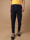 Man wearing a navy super soft navy cargo jogger with casual styling on a gray background