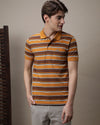 Man wearing a brown slim fit polo in striped brown with casual styling on a gray background