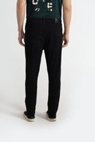 Person wearing black pants and a green shirt with white text on a white background