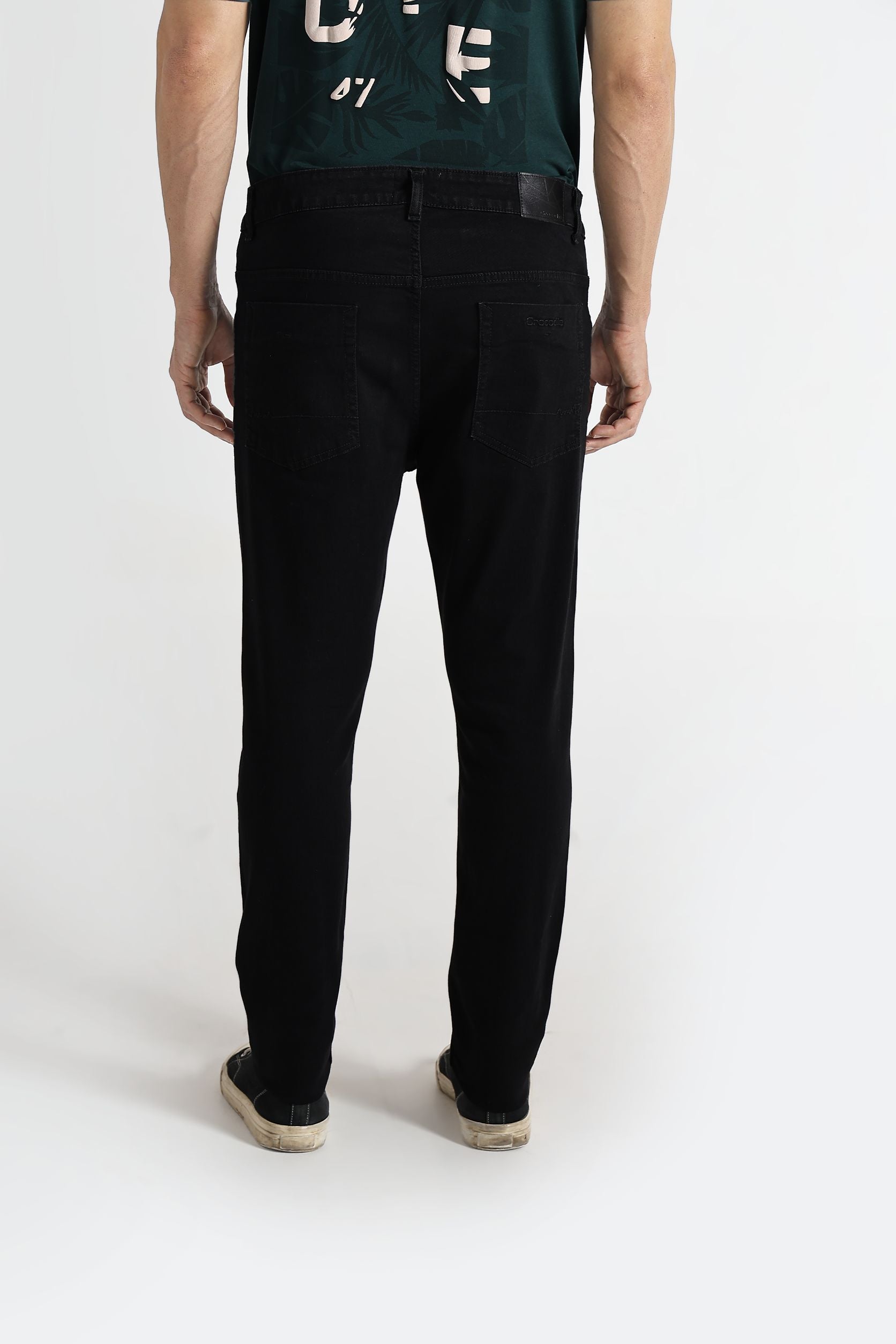 Person wearing black pants and a green shirt with white text on a white background