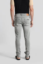 Person wearing gray jeans on a plain background