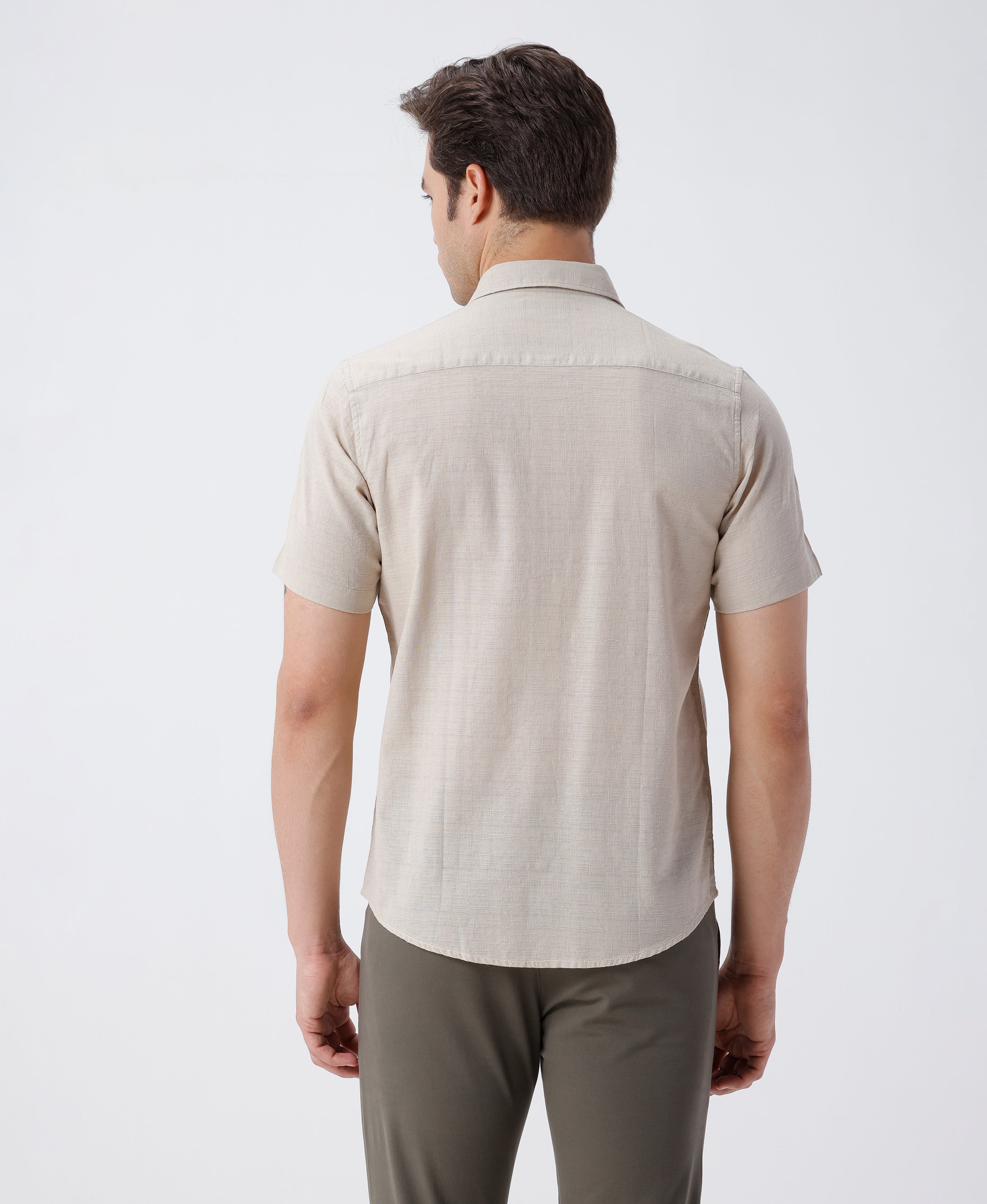 Man wearing a beige pure cotton textured shirt beige on a light gray background