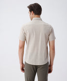Man wearing a beige pure cotton textured shirt beige on a light gray background