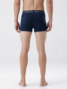 Person wearing navy blue boxer briefs on a white background