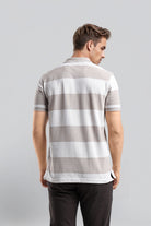 Man wearing a gray and white striped polo shirt on a light gray background