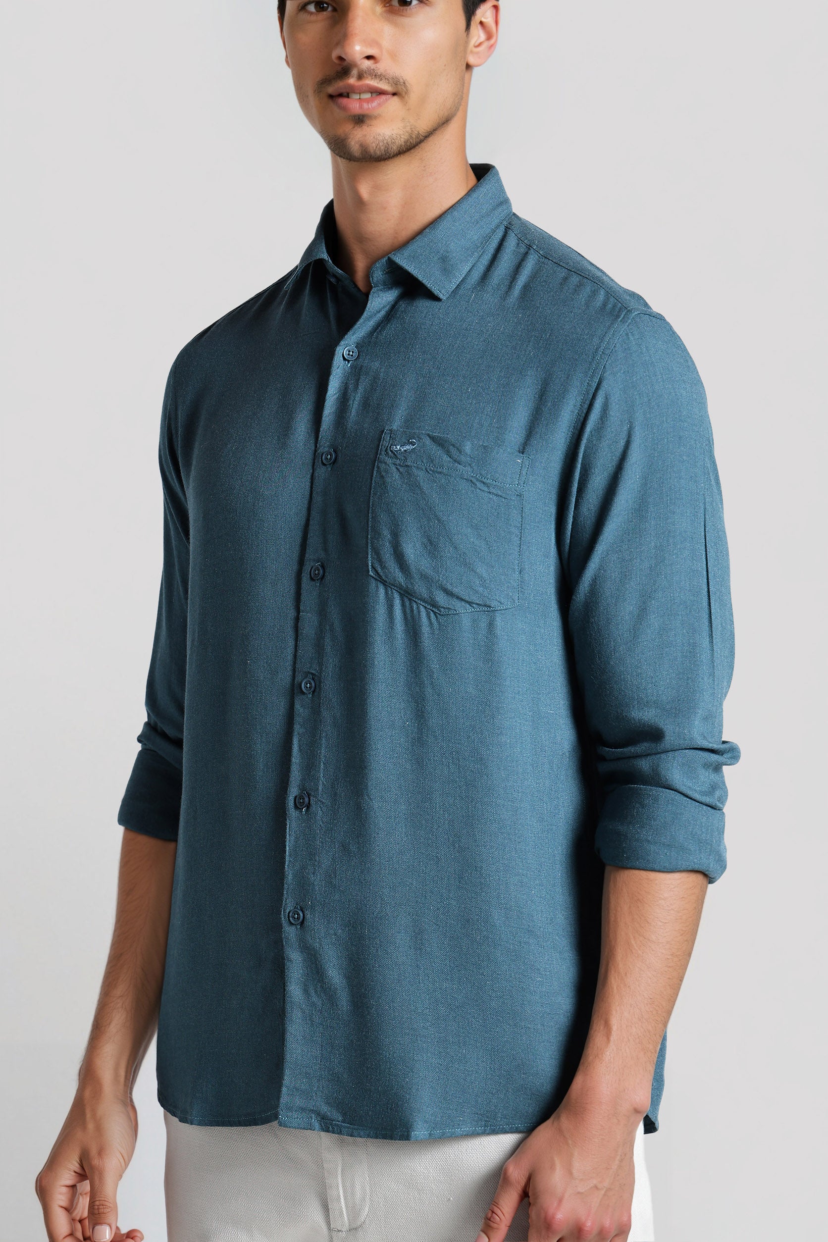 Man wearing a blue button-up shirt on a white background