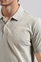 Beige polo shirt with 'Cole 1947' branding on a plain background