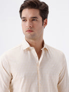Man wearing a geomentic diamond print shirt on a light gray background