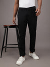 Man wearing a black slim fit solid casual trouser black with casual styling on a gray background