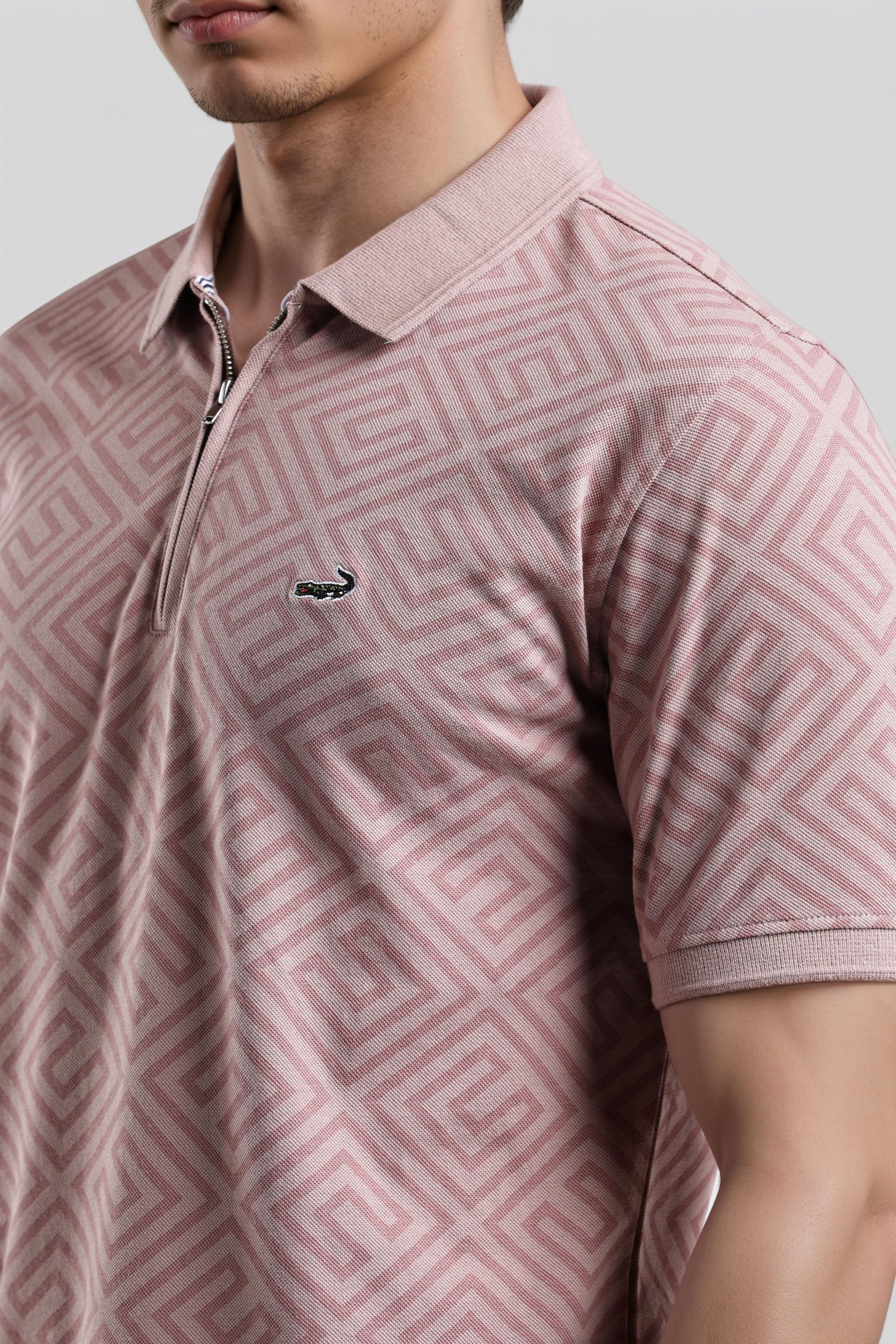 Pink patterned polo shirt with a small logo on a plain background
