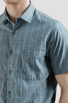 Close-up of a person wearing a blue striped shirt on a light gray background
