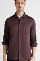 Man wearing a maroon button-up shirt on a white background