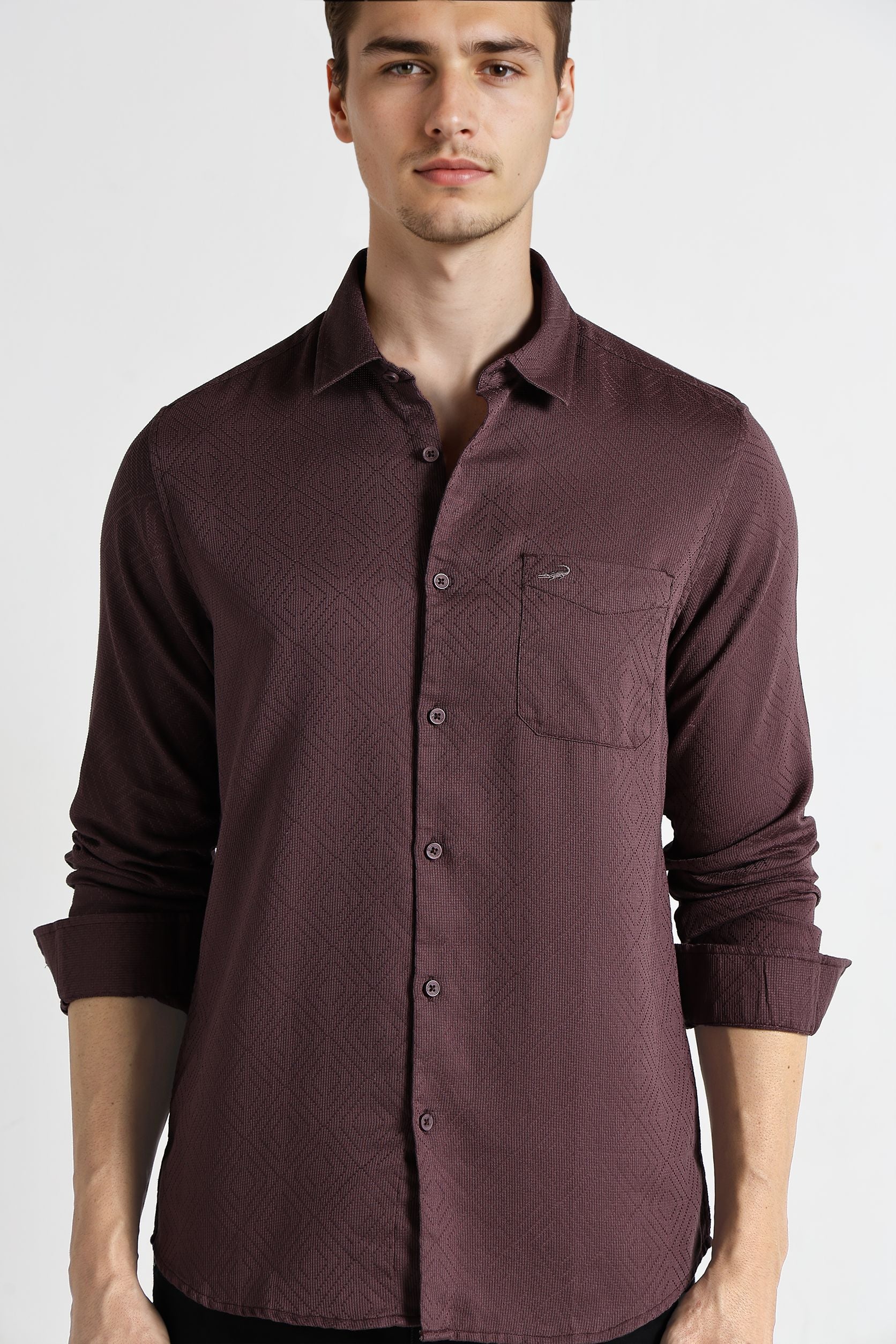 Man wearing a maroon button-up shirt on a white background