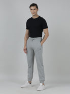 Man wearing a black t-shirt and gray sweatpants on a plain background