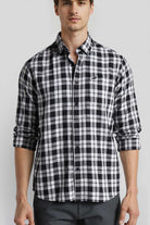 Man wearing a black and white checkered shirt on a light gray background
