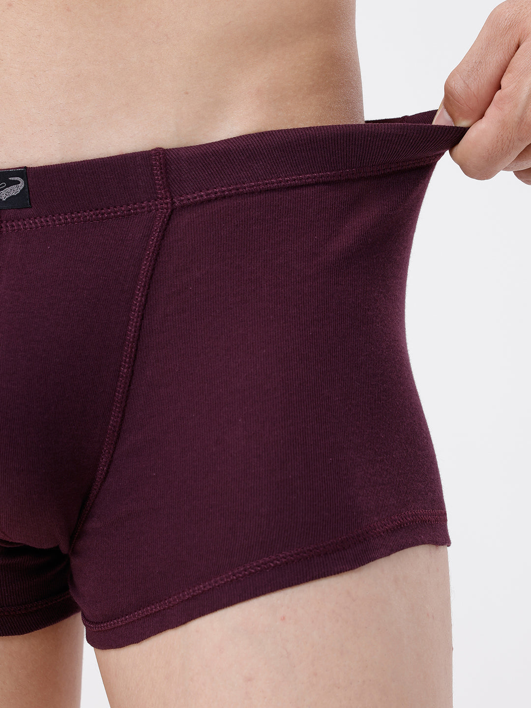 Maroon boxer briefs being held up against a white background