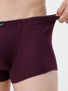 Maroon boxer briefs being held up against a white background