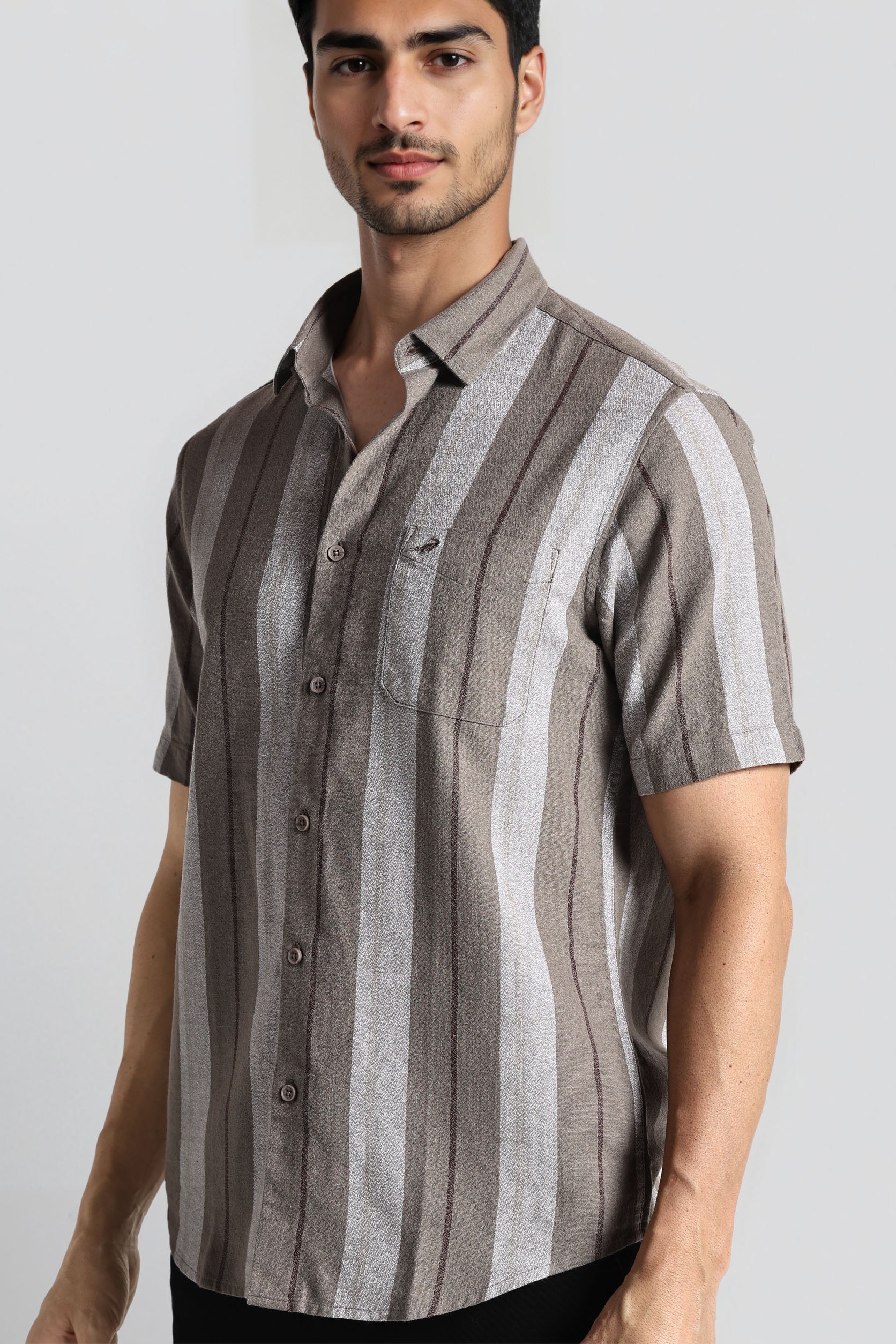 Man wearing a striped shirt with a plain background