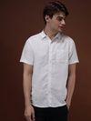 Man wearing a white white solid half sleeve linen shirt on a light gray background