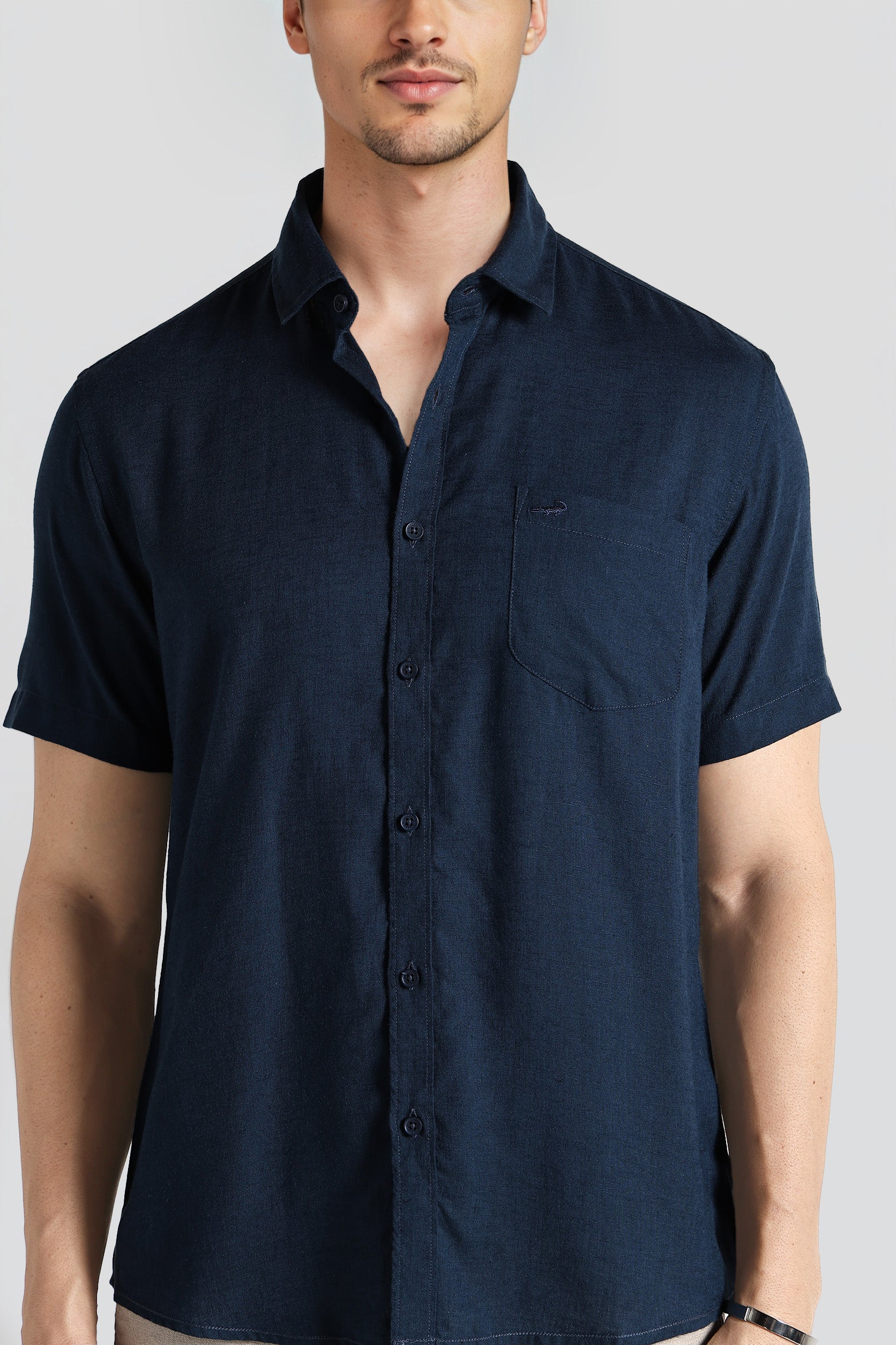 Man wearing a navy blue short-sleeve shirt on a white background