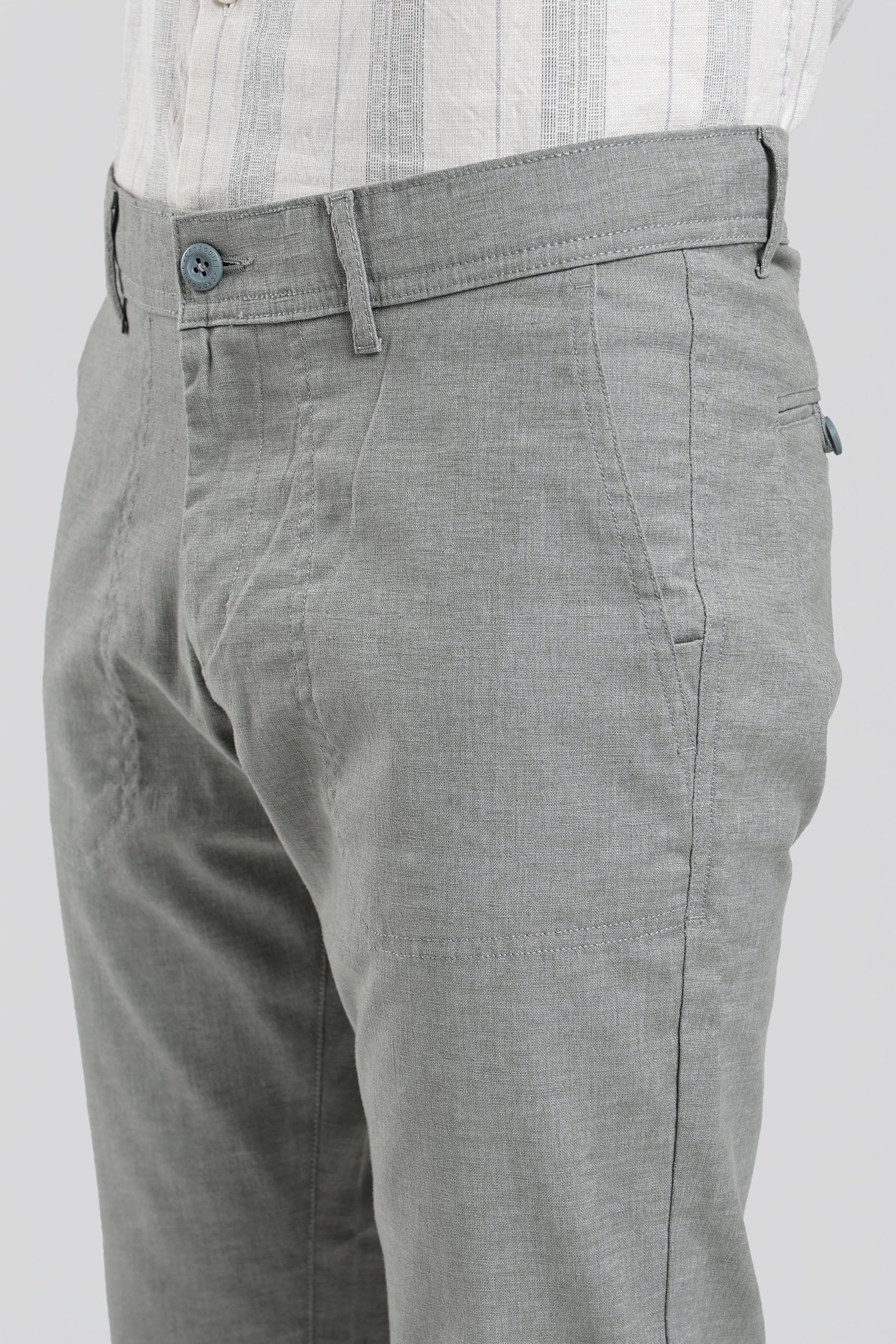 Gray pants worn with a white shirt on a plain background