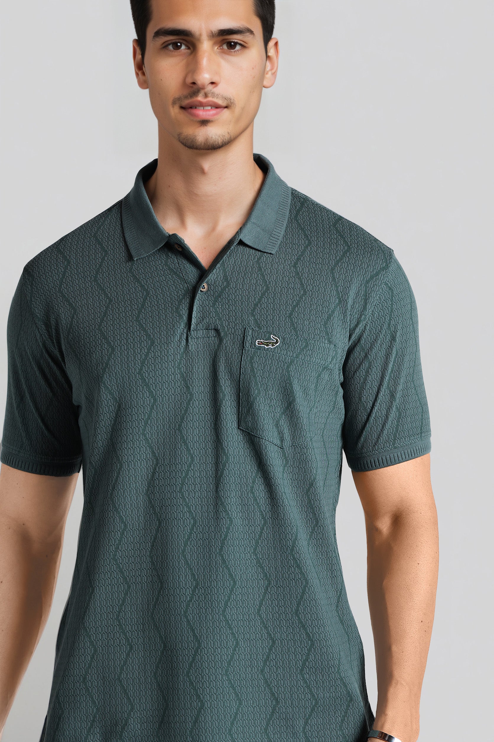 Man wearing a green patterned polo shirt with a brand logo on a gray background