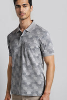 Man wearing a gray patterned polo shirt on a light gray background